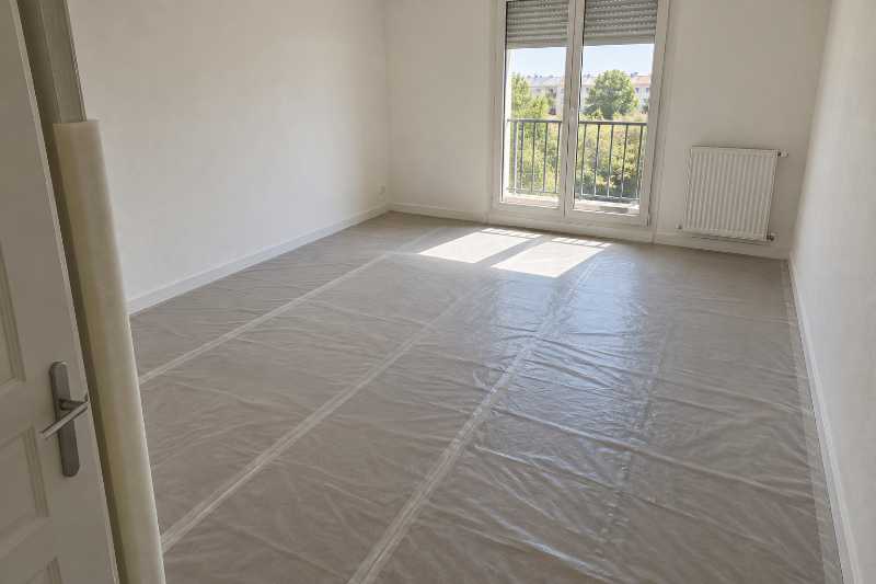 Film de protection déroulé sur le sol neuf d'un logement encore entièrement vide